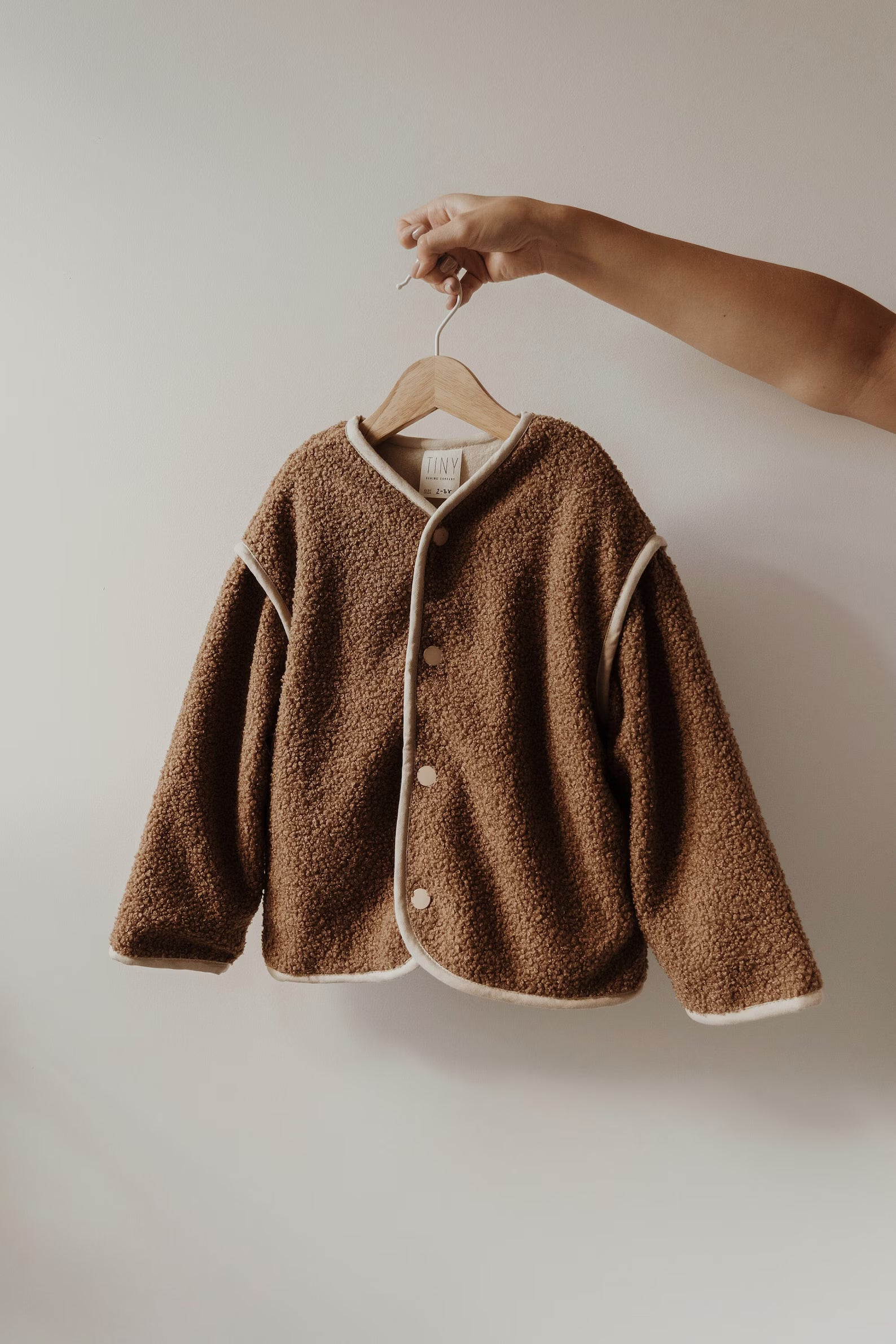 Bruin baby vest van teddy stof met knoopsluiting aan hanger