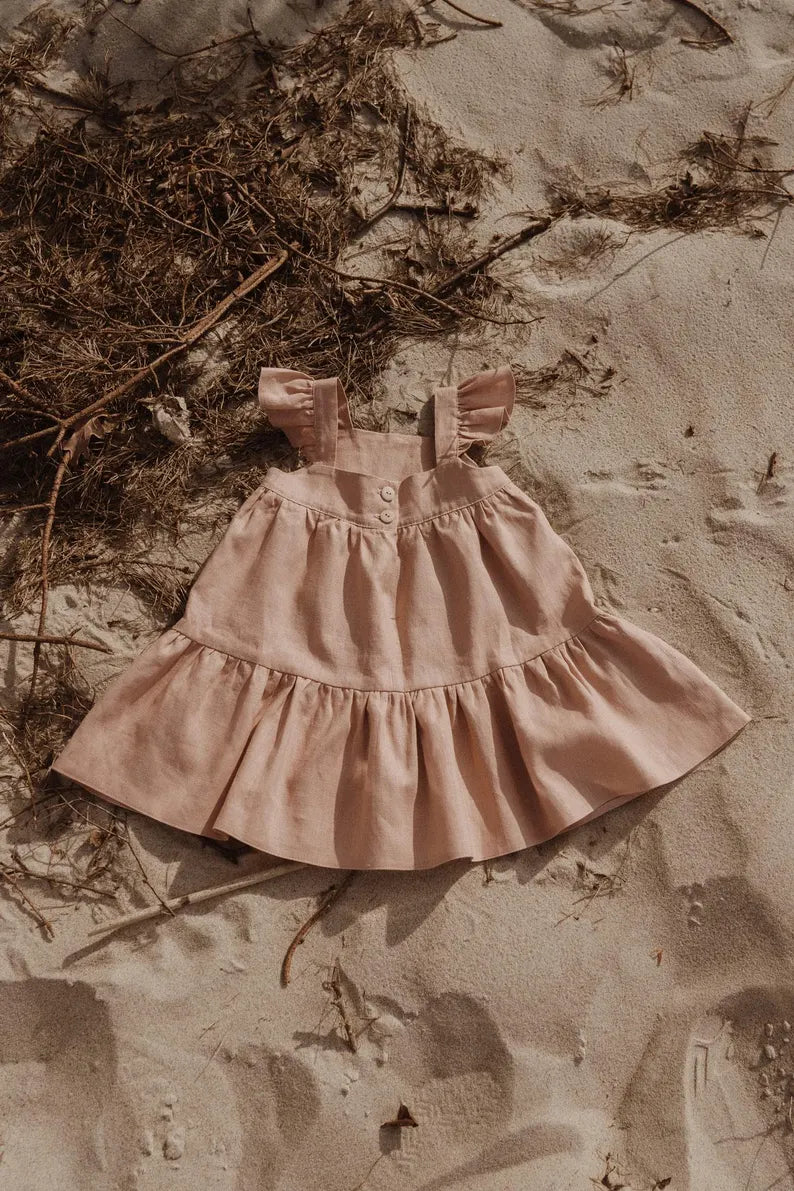 Elegante roze kinderjurk met speelse schouderruches en soepele rok